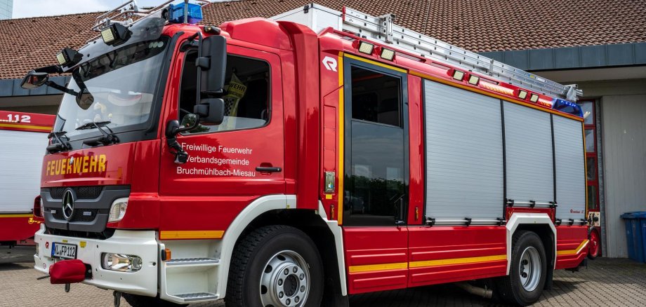 Feuerwehrauto von der Seite vor dem Gerätehaus.
