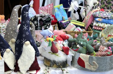 Zwei große genähte Zwerge und kleine genähte Elche an einem Stand.