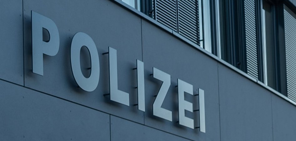 Polizeiinspektion Landstuhl Seitliche Aufnahme des Polizeiinspektionsgebäudes Landstuhl. Das graue Gebäude träge den hellgrauen Schriftzug Polizei